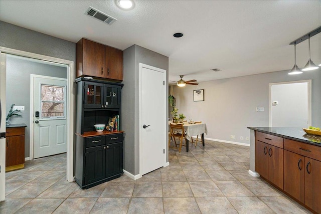 5014 Little Valley Rd, Leander, TX 78641 - kitchen featuring a ceiling fan, dark countertops, pendant lighting, and light tile patterned flooring