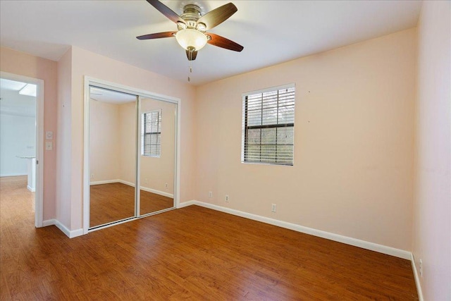 5014 Little Valley Rd, Leander, TX 78641 - unfurnished bedroom with wood finished floors, a closet, multiple windows, and ceiling fan