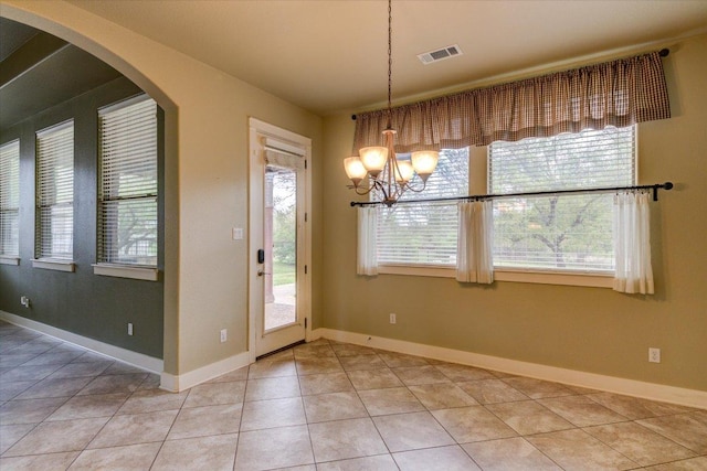 10242 Brangus Rd, Driftwood, TX 78619 - unfurnished dining area featuring light tile patterned floors, a chandelier, and arched walkways
