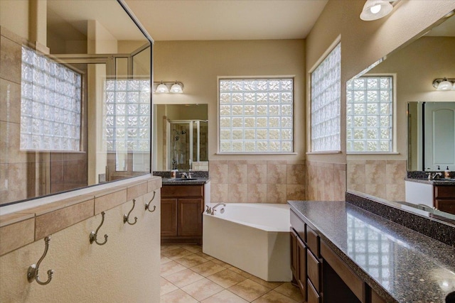 10242 Brangus Rd, Driftwood, TX 78619 - bathroom with tile patterned flooring, a shower stall, a bath, two vanities, and tile walls