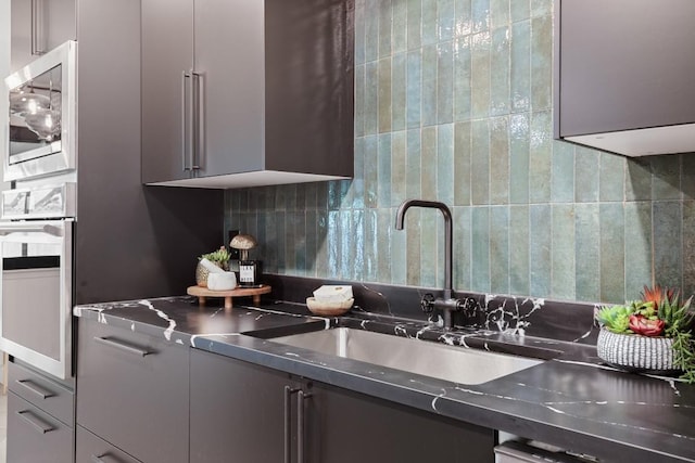3503 Gable Dr, Austin, TX 78759 - kitchen with stainless steel countertops, stainless steel appliances, backsplash, modern cabinets, and gray cabinets