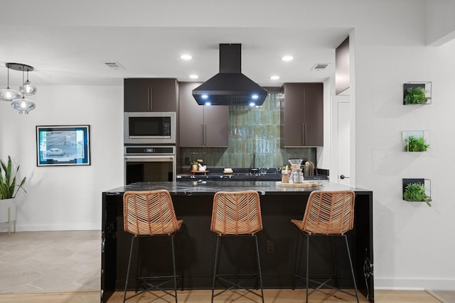 3503 Gable Dr, Austin, TX 78759 - kitchen with appliances with stainless steel finishes, island range hood, a breakfast bar area, decorative backsplash, and a peninsula