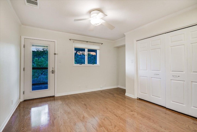 1607 Bay Hill Dr, Austin, TX 78746 - unfurnished bedroom featuring multiple windows, light wood-style floors, ornamental molding, a closet, and a ceiling fan