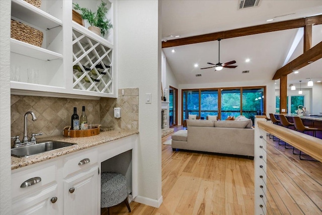 1607 Bay Hill Dr, Austin, TX 78746 - kitchen with a sink, light wood-style floors, white cabinets, backsplash, and ceiling fan