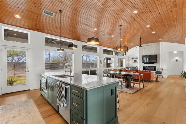 510 W 22nd St, Georgetown, TX 78626 - kitchen with green cabinets, a sink, lofted ceiling, wooden ceiling, and an island with sink