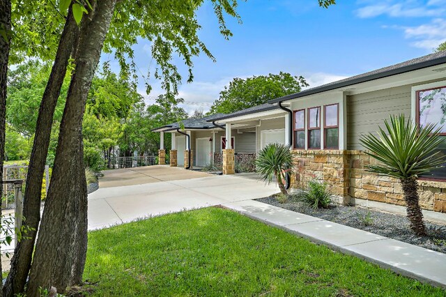 510 W 22nd St, Georgetown, TX 78626 - view of front facade with an attached garage, concrete driveway, stone siding, and a front yard