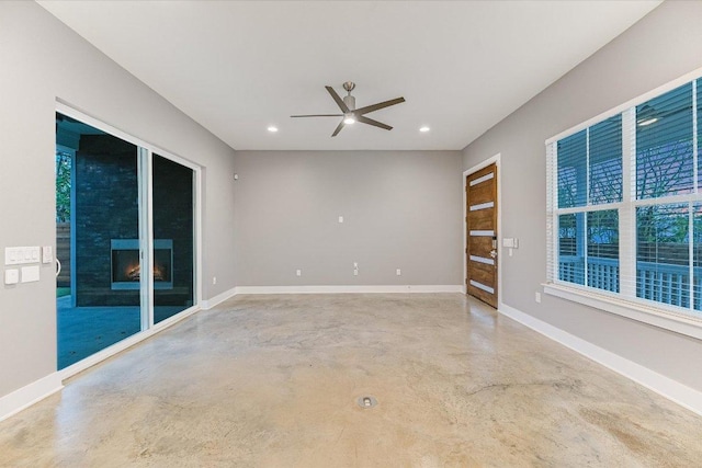 1811 Cedar Ave, Austin, TX 78702 - unfurnished room with concrete flooring, a ceiling fan, baseboards, recessed lighting, and a lit fireplace
