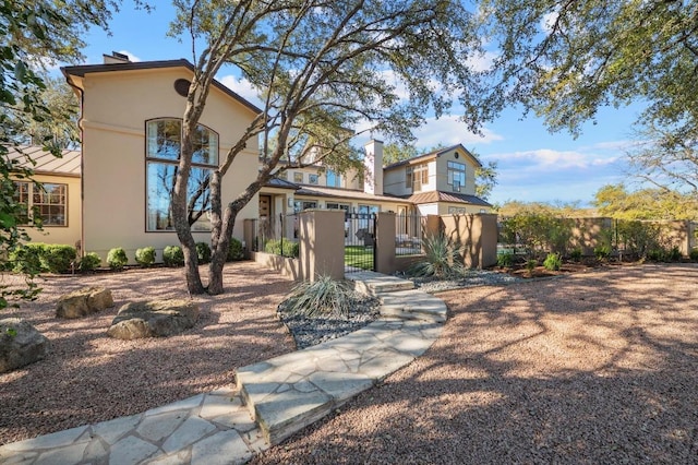 101 Knarr St, Austin, TX 78734 - back of house featuring a gate, stucco siding, and a chimney