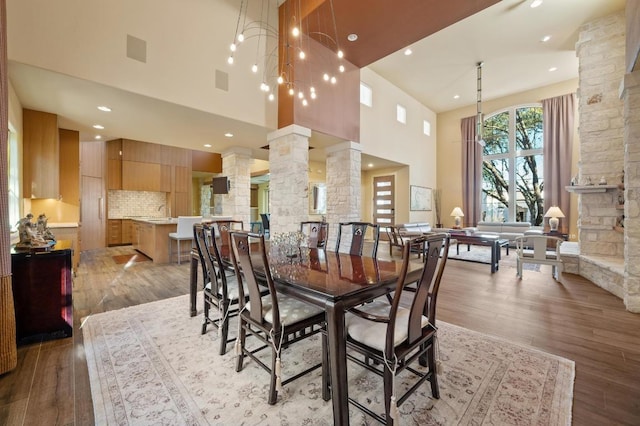 101 Knarr St, Austin, TX 78734 - dining room with decorative columns, a towering ceiling, light wood finished floors, and recessed lighting
