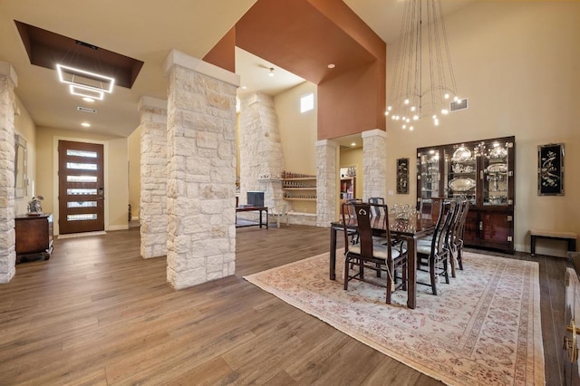 101 Knarr St, Austin, TX 78734 - dining area featuring ornate columns, wood finished floors, a chandelier, and a high ceiling