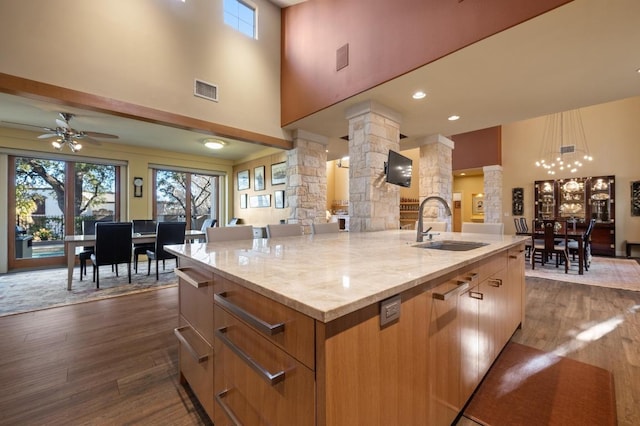 101 Knarr St, Austin, TX 78734 - kitchen with ornate columns, a high ceiling, dark wood-type flooring, plenty of natural light, and a center island with sink