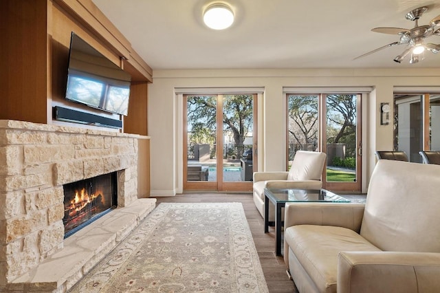 101 Knarr St, Austin, TX 78734 - living area with healthy amount of natural light, a ceiling fan, a fireplace, and wood finished floors