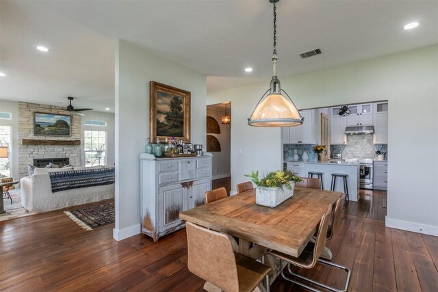 18190 Round Hall Rd, Holland, TX 76534 - dining room with a ceiling fan, a fireplace, dark wood-style floors, baseboards, and recessed lighting