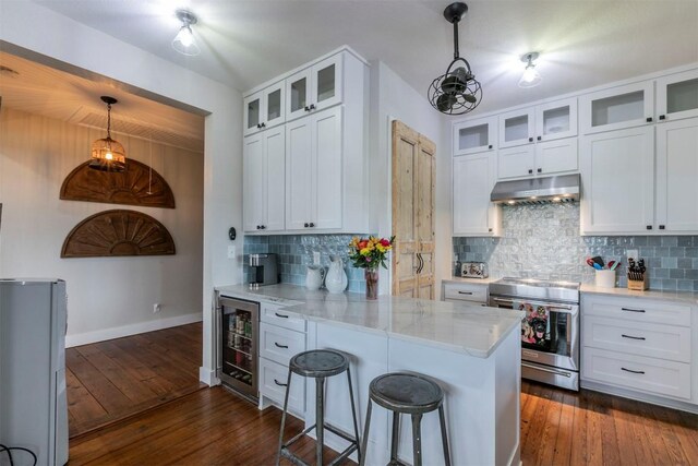 18190 Round Hall Rd, Holland, TX 76534 - kitchen with stainless steel range with electric stovetop, a peninsula, dark wood finished floors, under cabinet range hood, and beverage cooler
