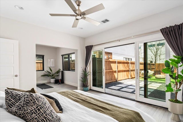 bedroom with access to exterior, wood finished floors, baseboards, and ceiling fan