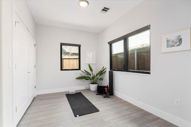 unfurnished room featuring baseboards and light wood-type flooring