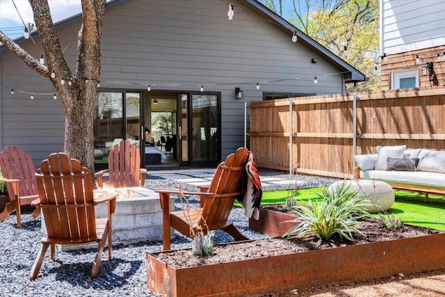 view of patio / terrace with fence and an outdoor living space with a fire pit