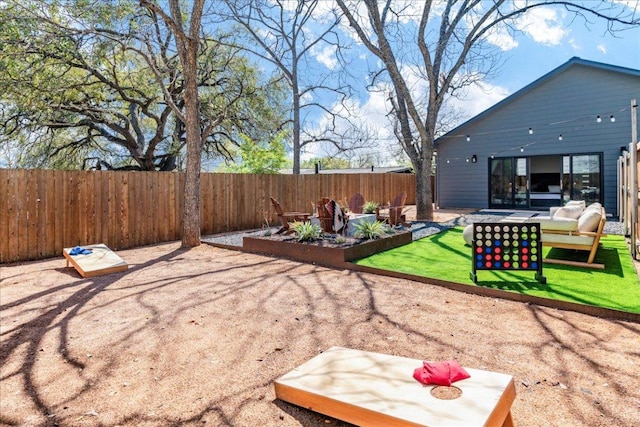 fenced backyard featuring a patio, a vegetable garden, and an outdoor living space