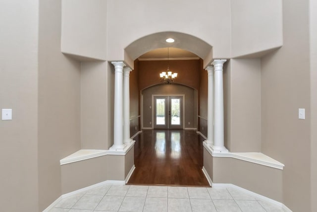 8016 Tahoe Parke Cir, Austin, TX 78726 - hallway featuring ornate columns, french doors, arched walkways, light tile patterned floors, and a high ceiling