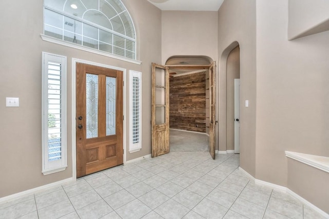 8016 Tahoe Parke Cir, Austin, TX 78726 - entryway with baseboards, light tile patterned floors, a towering ceiling, and arched walkways