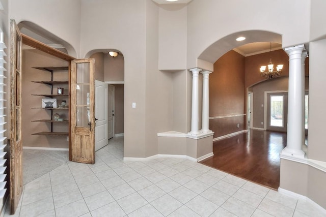 8016 Tahoe Parke Cir, Austin, TX 78726 - entrance foyer featuring a towering ceiling, arched walkways, light tile patterned flooring, baseboards, and decorative columns