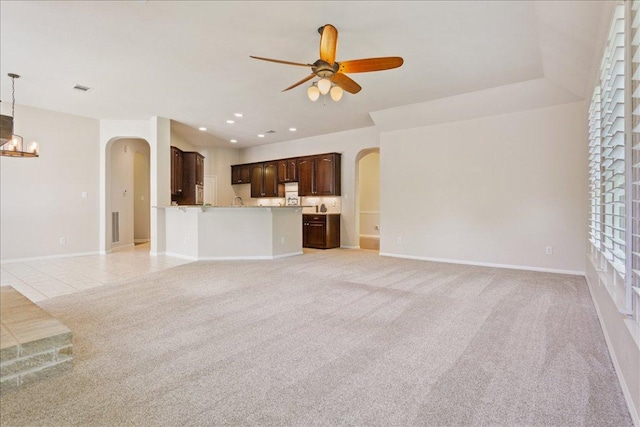 8016 Tahoe Parke Cir, Austin, TX 78726 - unfurnished living room featuring arched walkways, ceiling fan, light colored carpet, a chandelier, and recessed lighting