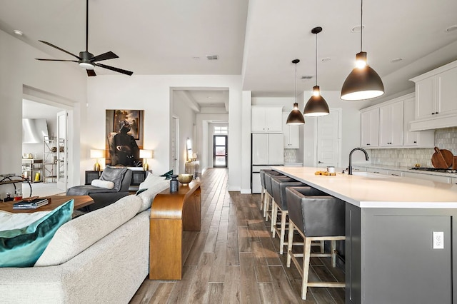 8112 Hubble Walk, Austin, TX 78744 - kitchen with open floor plan, a sink, ceiling fan, dark wood-type flooring, and a breakfast bar area