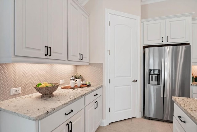 kitchen with stainless steel fridge with ice dispenser, backsplash, white cabinetry, and light tile patterned floors
