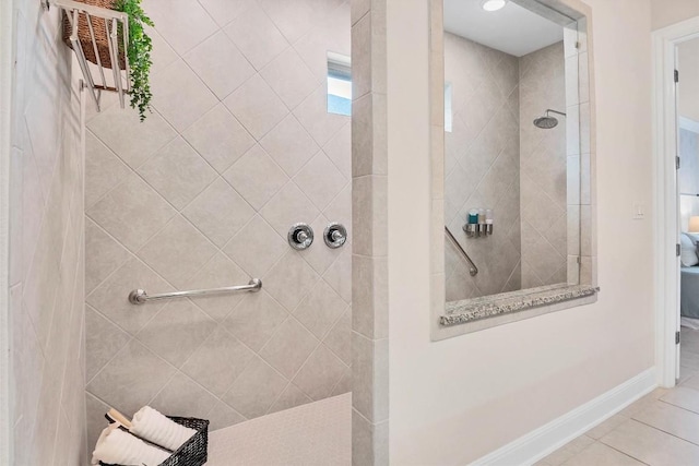full bath featuring tile patterned floors, baseboards, and a walk in shower