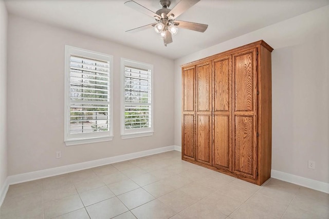 unfurnished bedroom featuring light tile patterned floors, baseboards, and ceiling fan