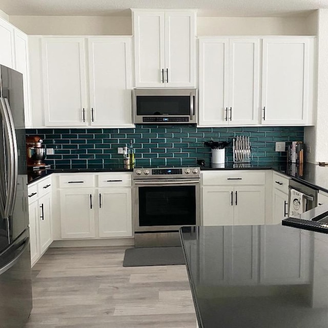 7900 Nightwing Rd, Austin, TX 78724 - kitchen with backsplash, white cabinets, appliances with stainless steel finishes, and light wood-type flooring
