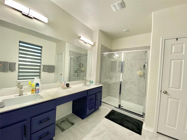 7900 Nightwing Rd, Austin, TX 78724 - bathroom with double vanity, a textured ceiling, a sink, and a stall shower