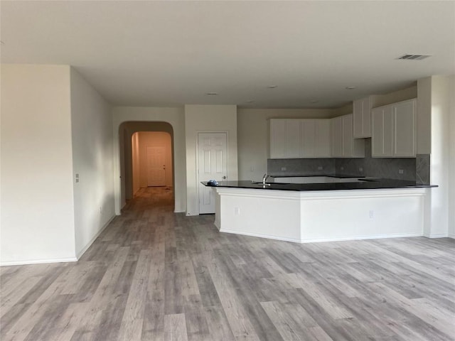 7900 Nightwing Rd, Austin, TX 78724 - kitchen with white cabinets, visible vents, dark countertops, tasteful backsplash, and arched walkways