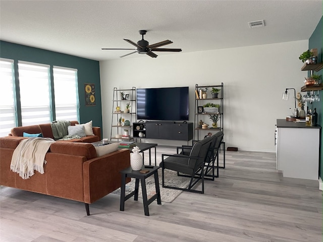 7900 Nightwing Rd, Austin, TX 78724 - living area with light wood-type flooring, a ceiling fan, a textured ceiling, and visible vents