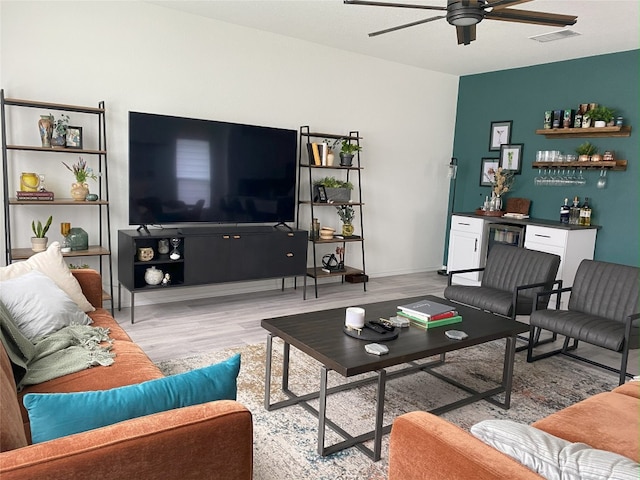 7900 Nightwing Rd, Austin, TX 78724 - living room featuring visible vents, baseboards, a ceiling fan, a dry bar, and light wood-style floors