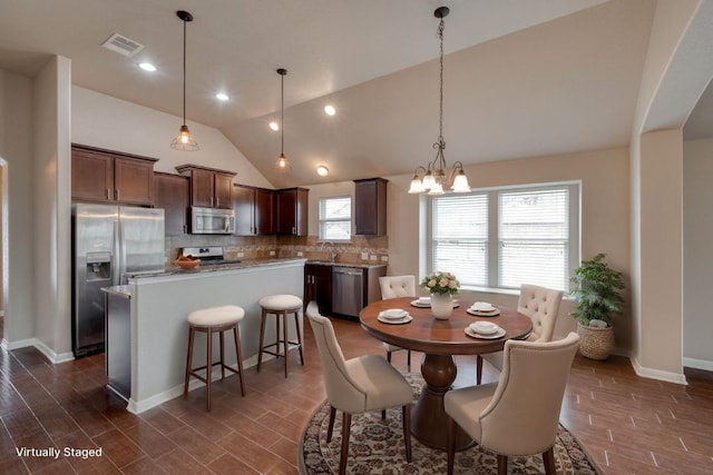 dining space featuring a chandelier, dark wood-style flooring, baseboards, and high vaulted ceiling