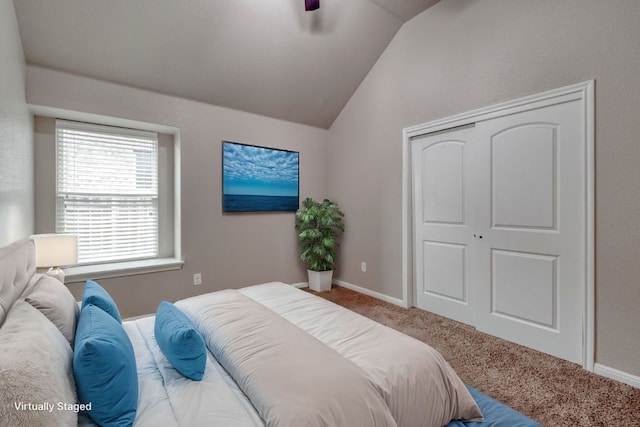 bedroom featuring lofted ceiling, carpet floors, a closet, baseboards, and ceiling fan