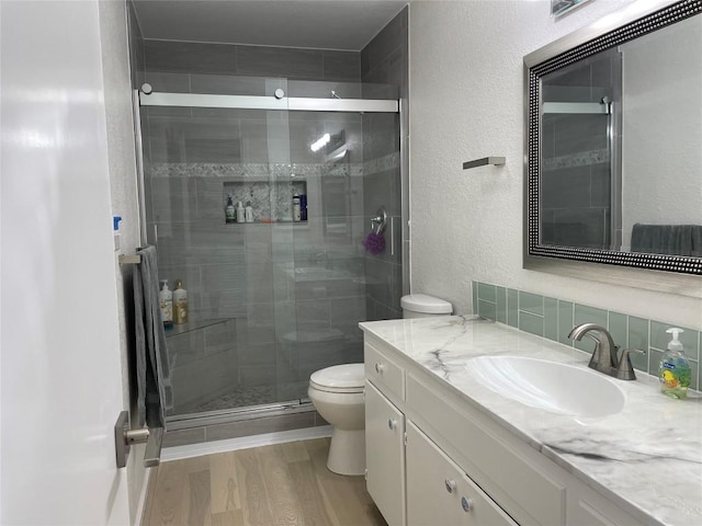 197 Port Saint Claire, Aransas Pass, TX 78336 - full bath with toilet, a textured wall, vanity, a stall shower, and wood finished floors