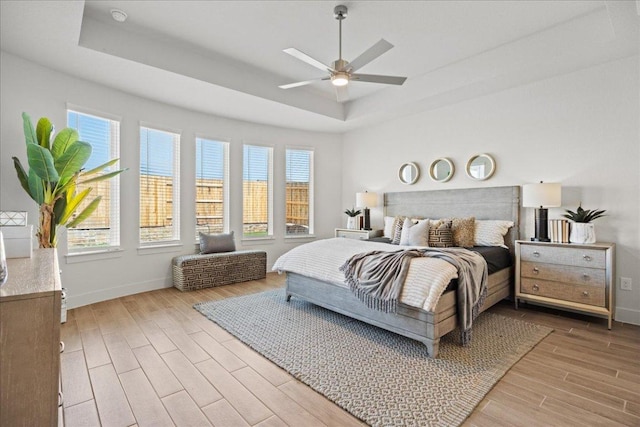 506 Diamondleaf Dr, Buda, TX 78610 - bedroom featuring a tray ceiling, wood finished floors, baseboards, and ceiling fan