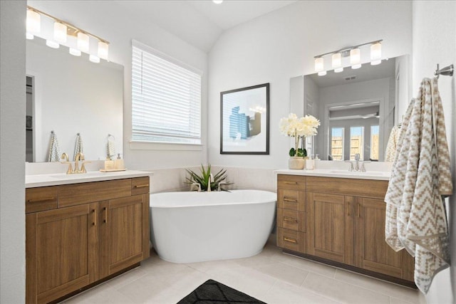 506 Diamondleaf Dr, Buda, TX 78610 - bathroom featuring two vanities, a soaking tub, and tile patterned floors