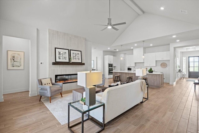 506 Diamondleaf Dr, Buda, TX 78610 - living room with baseboards, high vaulted ceiling, ceiling fan, beamed ceiling, and light wood-style floors