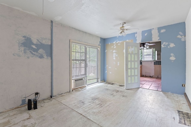 18309 Lake Oaks Dr, Jonestown, TX 78645 - unfurnished room featuring plenty of natural light, a ceiling fan, cooling unit, and wood finished floors