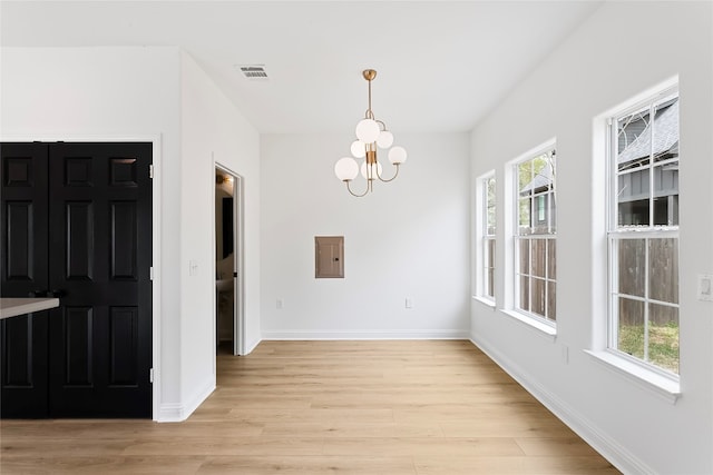 5408 Downs Dr Unit 1, Austin, TX 78721 - unfurnished dining area featuring light wood-style floors, electric panel, and a chandelier
