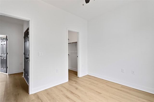 5408 Downs Dr Unit 1, Austin, TX 78721 - unfurnished bedroom featuring light wood-style flooring, a spacious closet, a closet, and a ceiling fan
