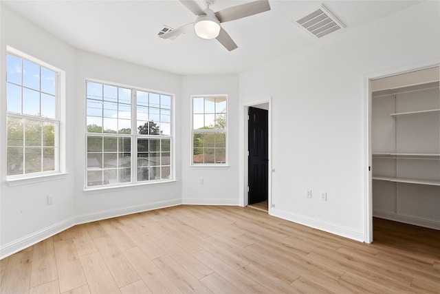 5408 Downs Dr Unit 1, Austin, TX 78721 - unfurnished bedroom with multiple windows, light wood-style flooring, and a spacious closet