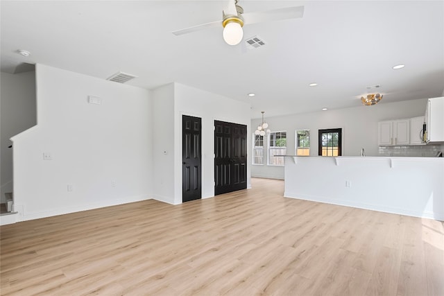 5408 Downs Dr Unit 1, Austin, TX 78721 - unfurnished living room featuring a ceiling fan, light wood-style floors, recessed lighting, and a chandelier