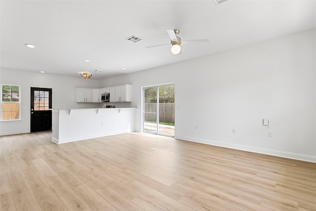 5408 Downs Dr Unit 1, Austin, TX 78721 - unfurnished living room featuring light wood-style floors, recessed lighting, and ceiling fan
