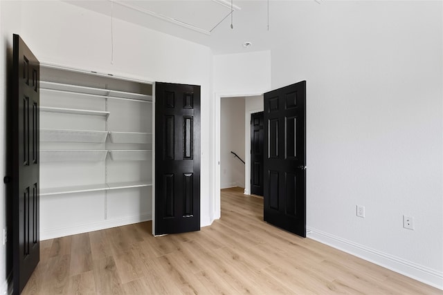 5408 Downs Dr Unit 1, Austin, TX 78721 - unfurnished bedroom featuring attic access, light wood-type flooring, and a closet