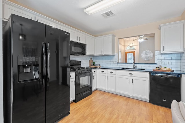 1142 Sundrop Pl, Round Rock, TX 78665 - kitchen featuring black appliances, dark countertops, white cabinets, and light wood finished floors