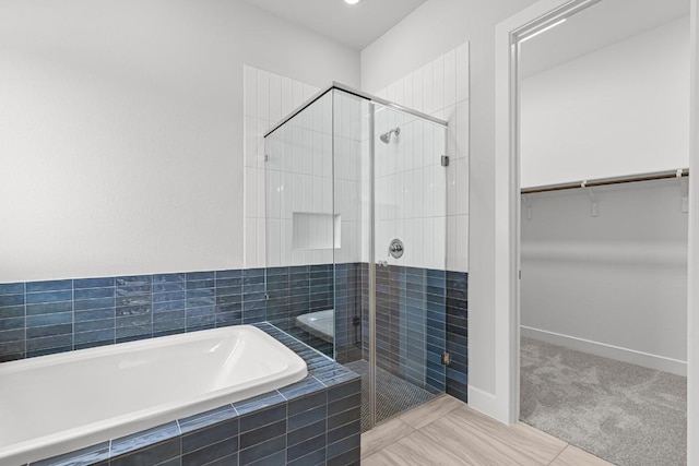 8212 Bouvreuil Dr, Austin, TX 78738 - bathroom featuring a garden tub, a shower stall, a walk in closet, and baseboards